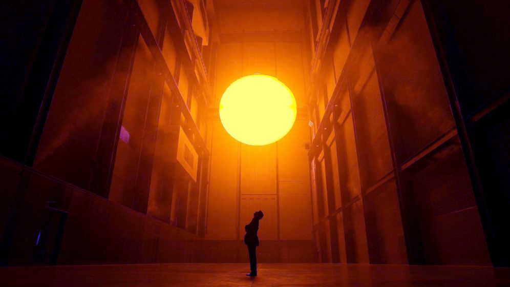 Danish environmental sculptur Olaf Eliasson, stands in the Turbine Hall at the Tate Modern art museum, London, and looks up at his art work entitled 'The Weather Project', Wednesday, Oct. 15, 2003. Eliasson has used mirrors, light, sound and mist to create a monochrome space that exposes and confronts the visitor. (AP Photo/Alastair Grant)